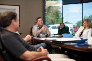A group of people sitting at a table during a meeting