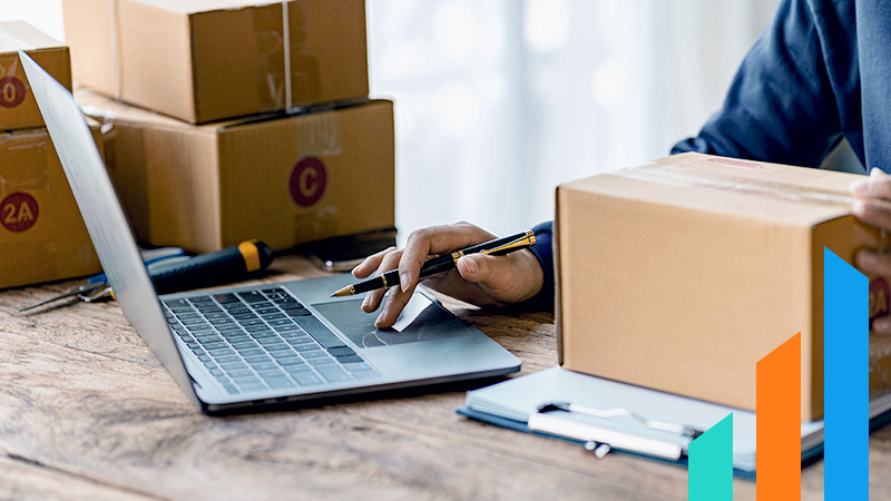 man working on his laptop in a warehouse for ecommerce business